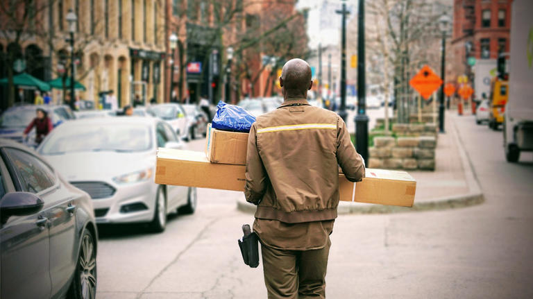 Delivery person carries boxes