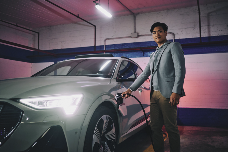 A driver charging his electric car in a parking garage