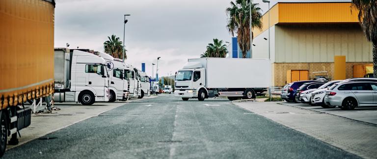 A fleet of trucks parked outside a warehouse.