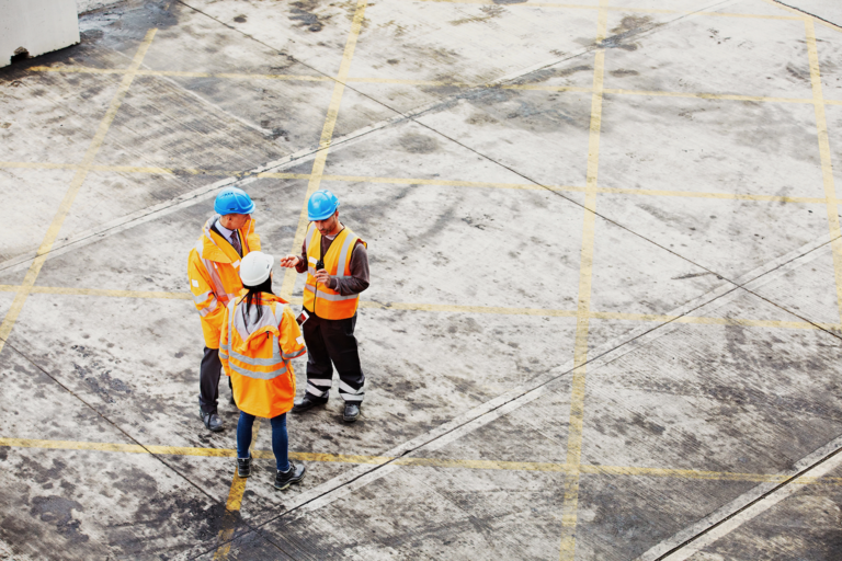 Three colleagues talking in an industrial area.
