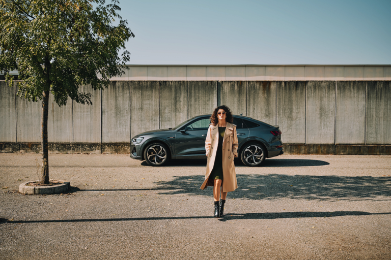 A woman walking away from her parked car.
