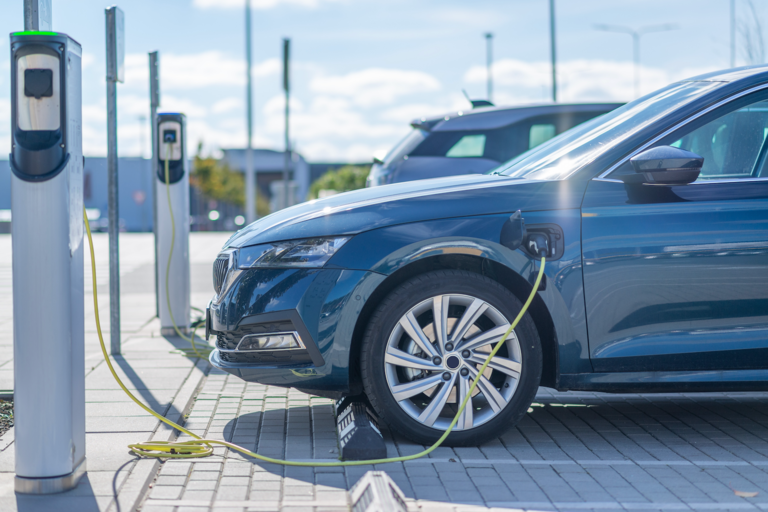 An electric vehicle charging at a charging station on a sunny day.