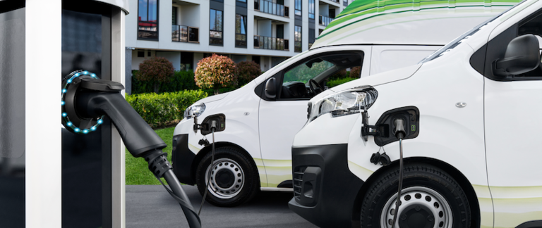 An electric truck docked at an electric charge station.