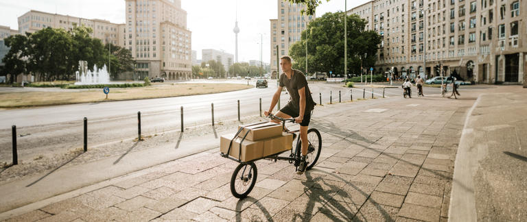 A delivery driver traveling on an eCargo bike through Berlin.