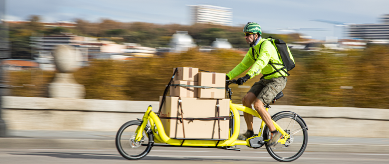 A cargo bike makes deliveries in a city.