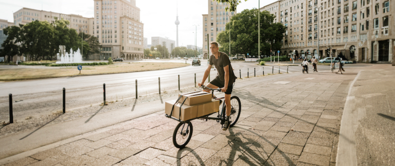 A delivery driver traveling on an eCargo bike through Berlin.