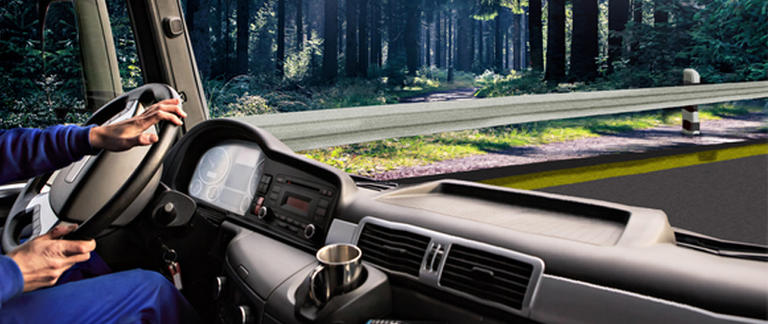 Highway seen from the perspective of a truck driver with his hands on the steering wheel
