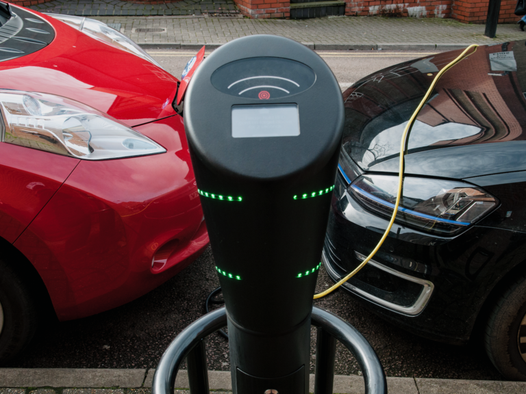 Two cars share a charging point to charge their EVs.