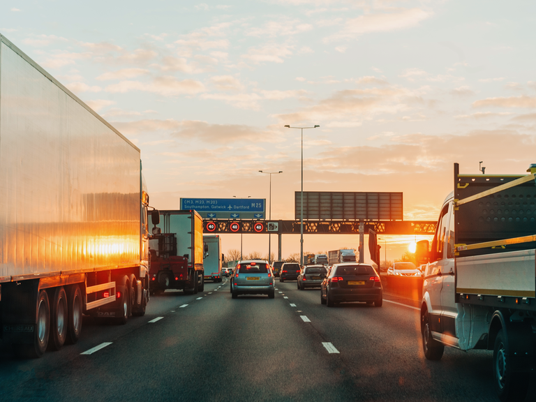 Traffic flows down a British motorway (highway) at sunset.