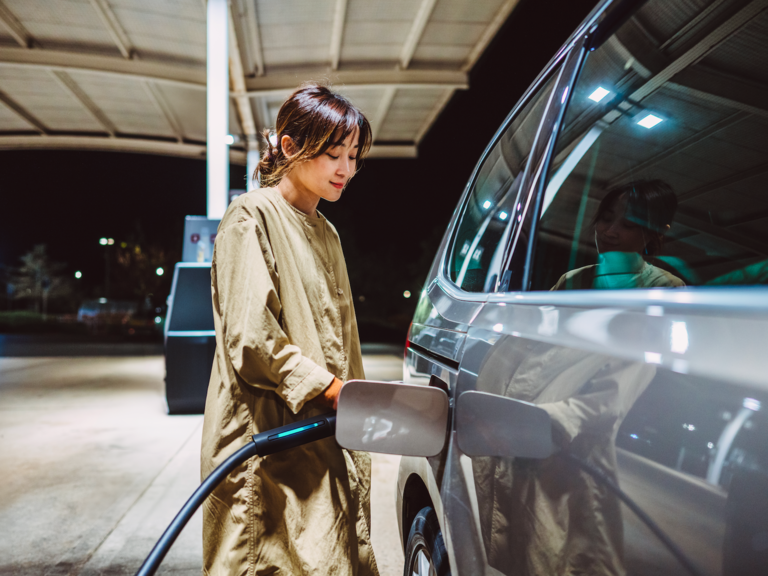 A woman charging her electric vehicle at an EV charge point.