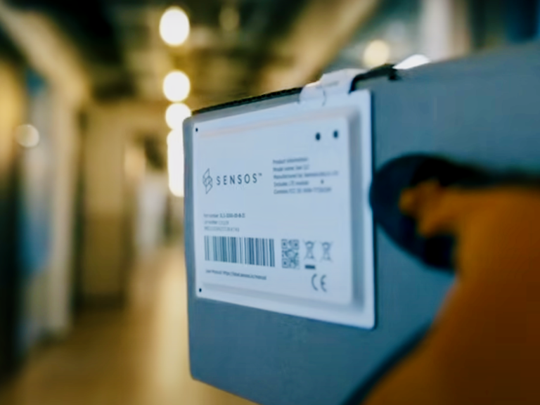 A man carries a package that features a Sensos label.