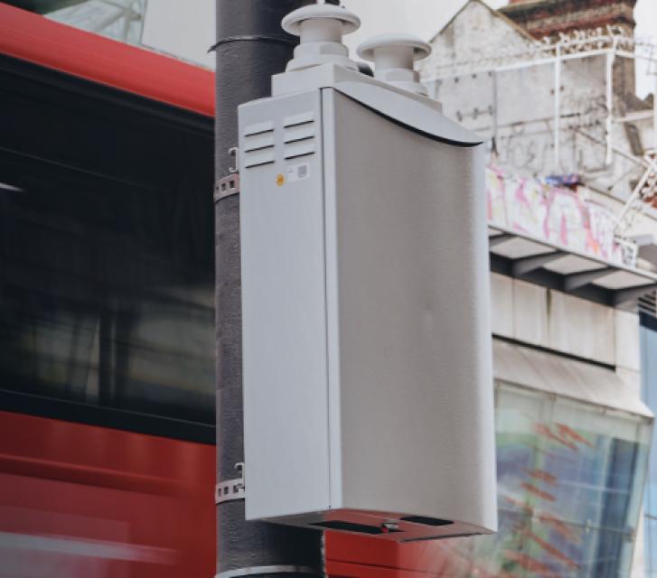 TfL buw in front of TfL train station with a Bosch pollution detector