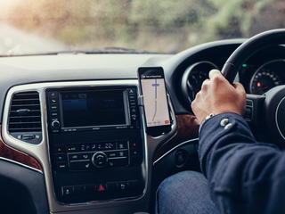 高精度位置情報を用いた自動車用のルート検索システムで運転する男性