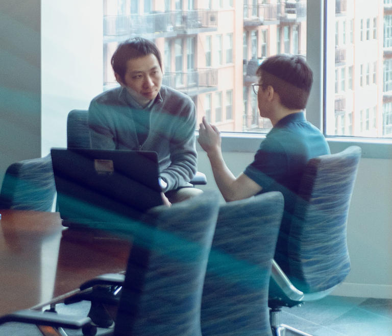 two people chatting in a conference room