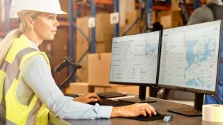 Warehouse worker at a workstation tracking assets in real-time with an end-to-end solution